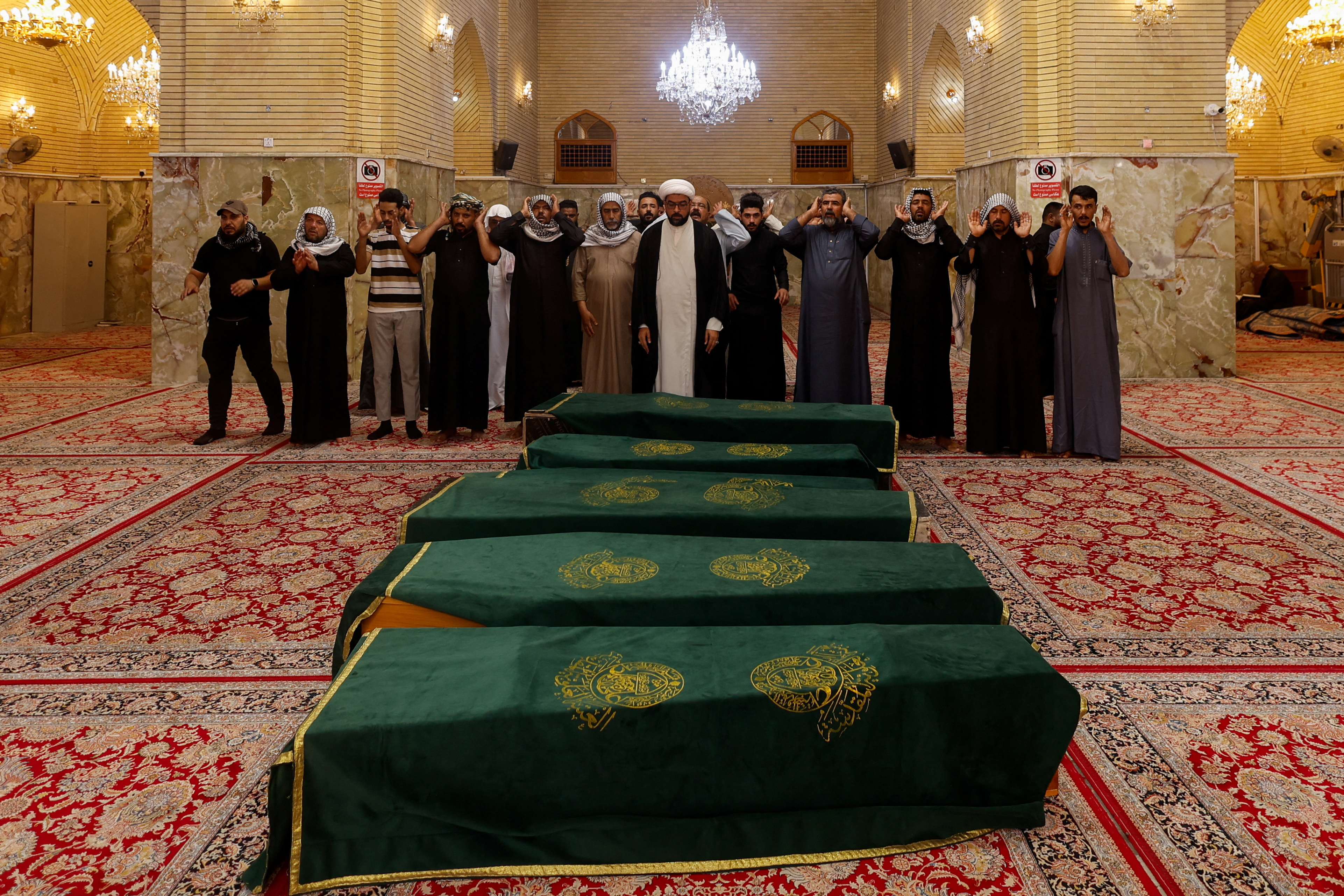 Mourners pray during the funeral of children killed after a refrigerator truck veered into a group of young people in Basra, in Najaf