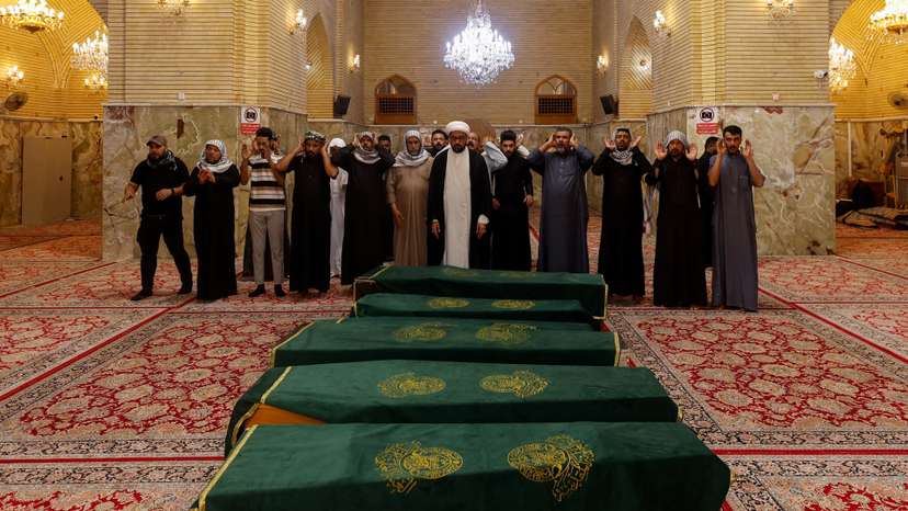 Mourners pray during the funeral of children killed after a refrigerator truck veered into a group of young people in Basra, in Najaf