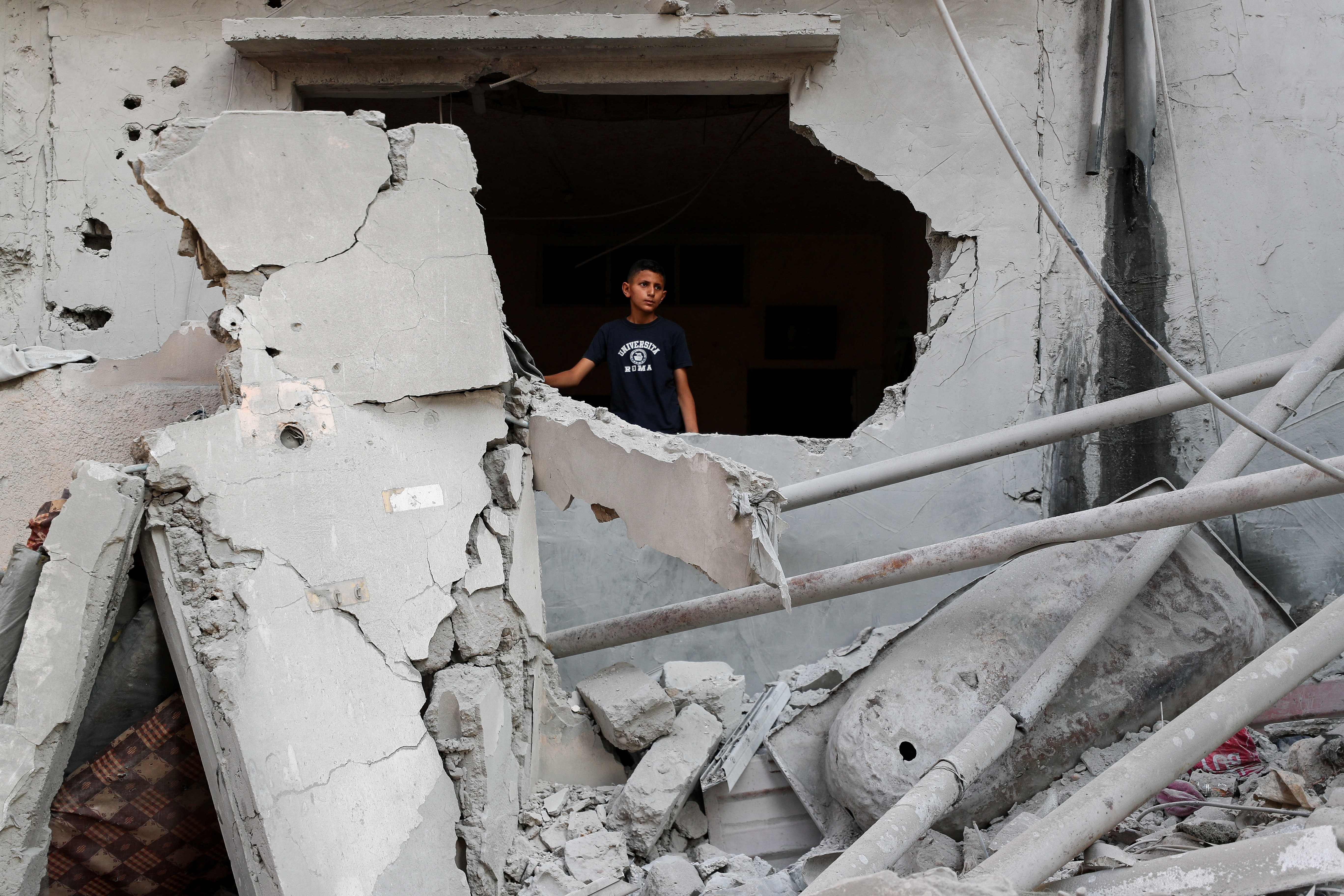 Palestinians inspect the site of an overnight Israeli air strike on a house, in Gaza City