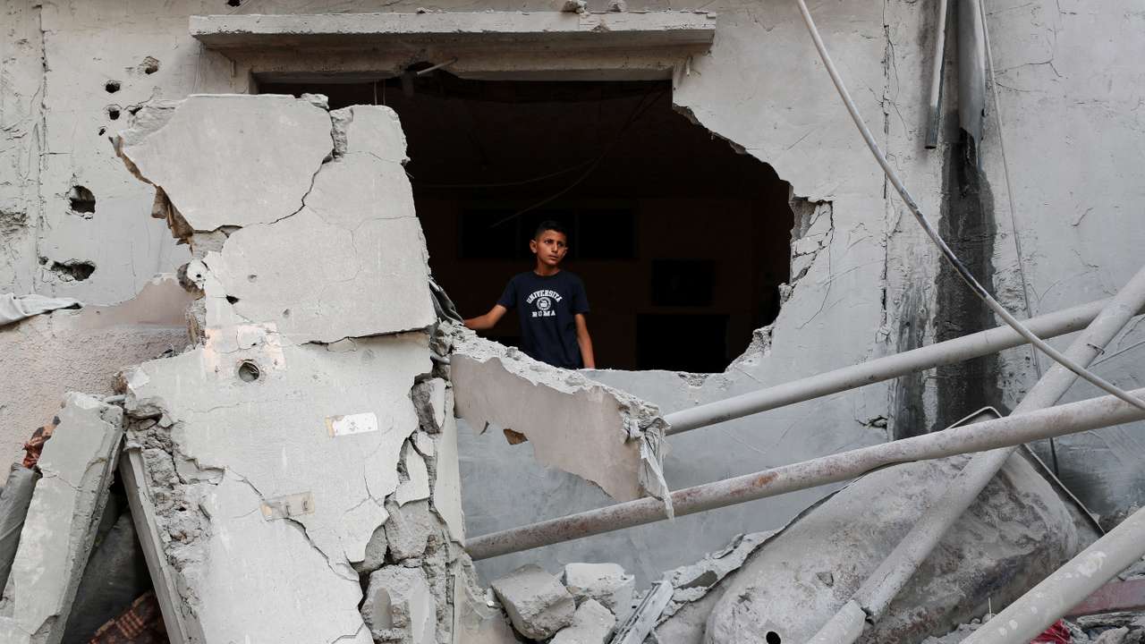 Palestinians inspect the site of an overnight Israeli air strike on a house, in Gaza City