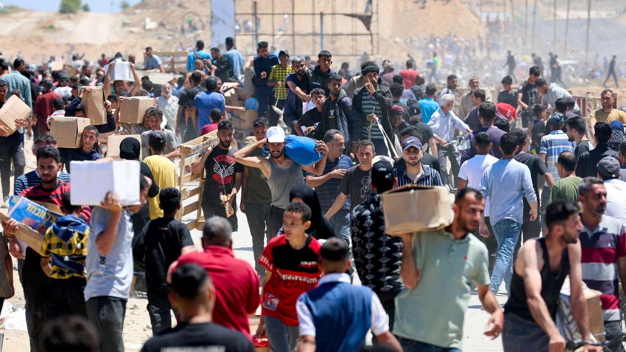 Palestinians carry aid supplies which they received from the U.S.-backed Gaza Humanitarian Foundation