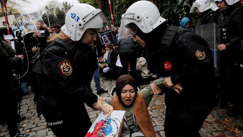 FILE PHOTO: Ethnic Uyghur demonstrators scuffle with riot police as they try to continue a sit-in protest against China