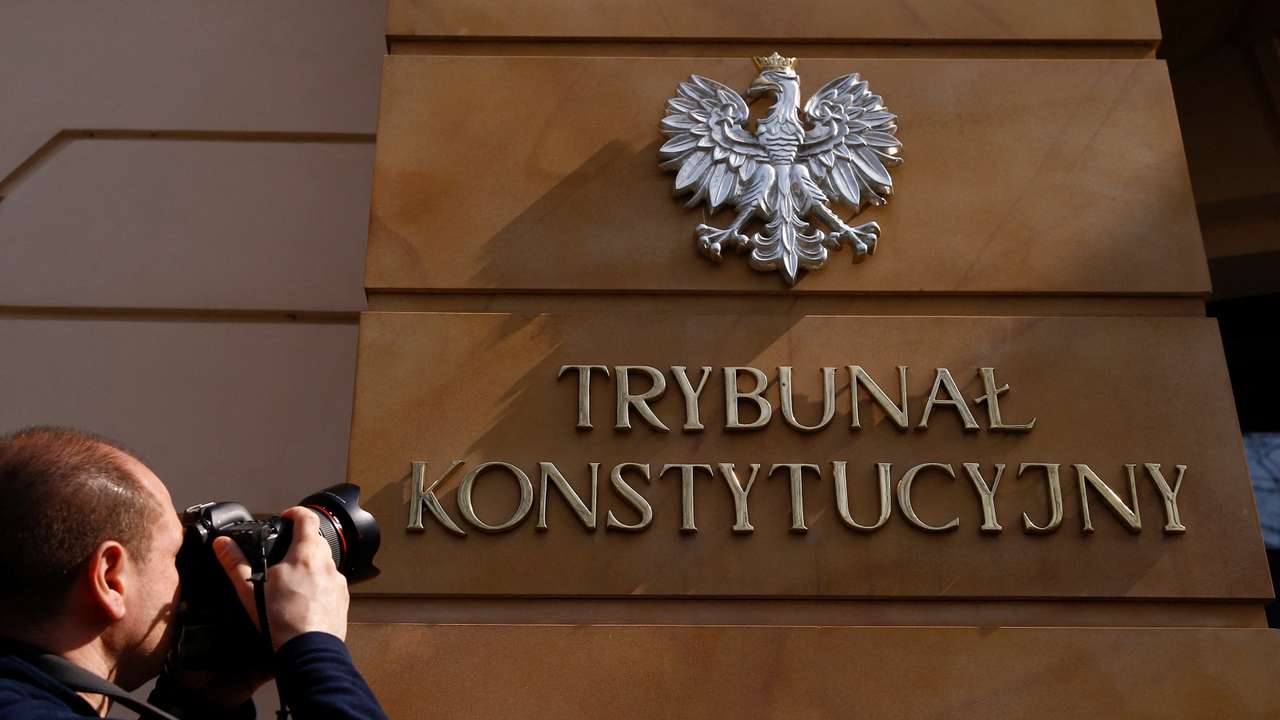 FILE PHOTO: A photographer takes a picture of the sign at the entrance to Poland's constitutional court in Warsaw