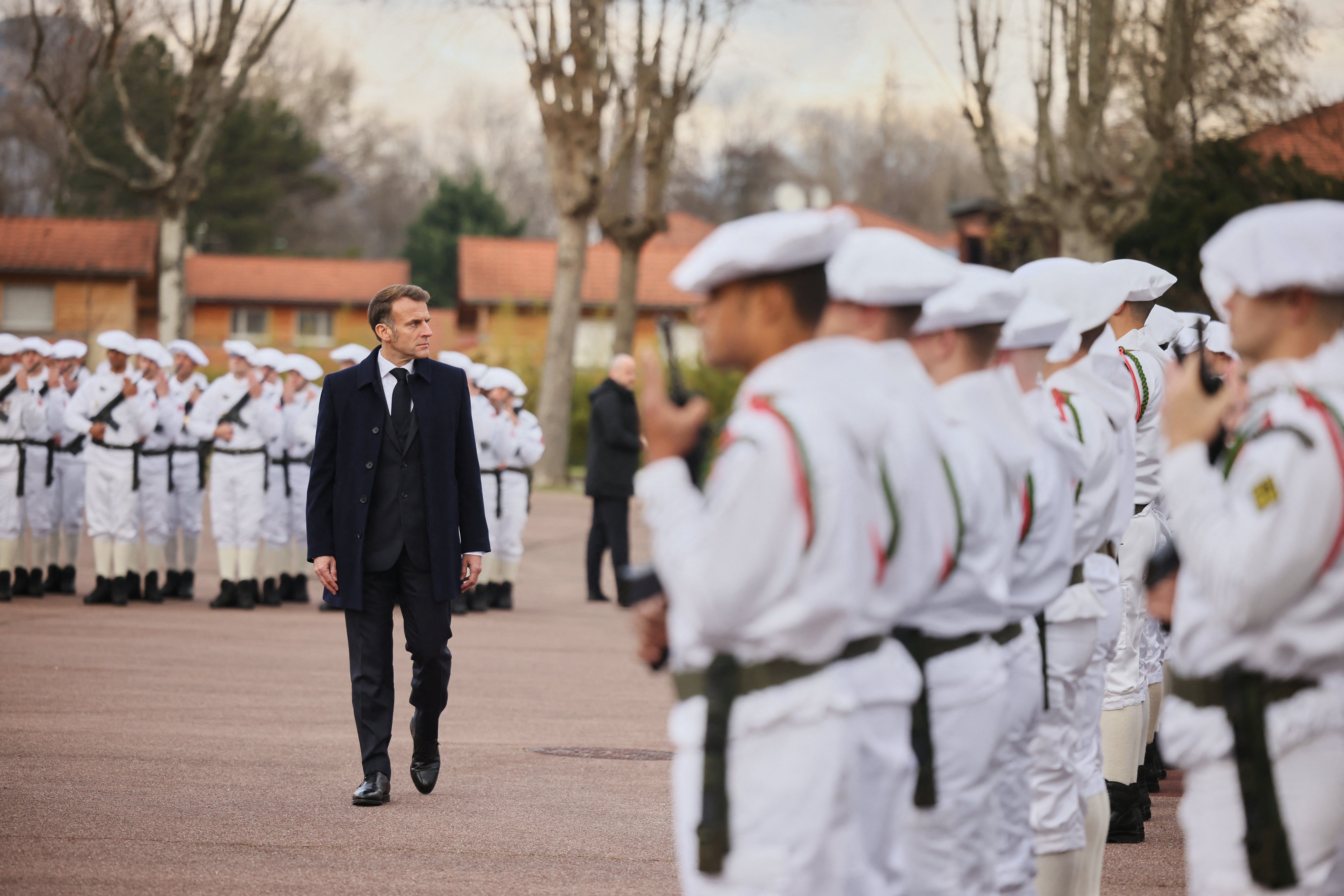 France's President Macron reviews the troops prior to his speech to unveil a new national military service at the military base in Varces