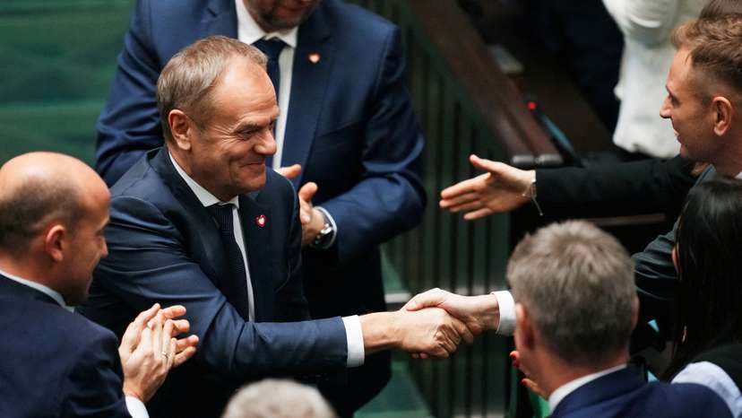 Members of the Polish Parliament congratulate newly appointed Polish Prime Minister Donald Tusk after he won the vote of confidence for his government, in Parliament, in Warsaw