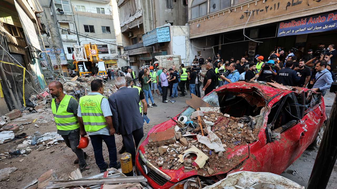 People gather at the site of an Israeli strike in Beirut's southern suburbs