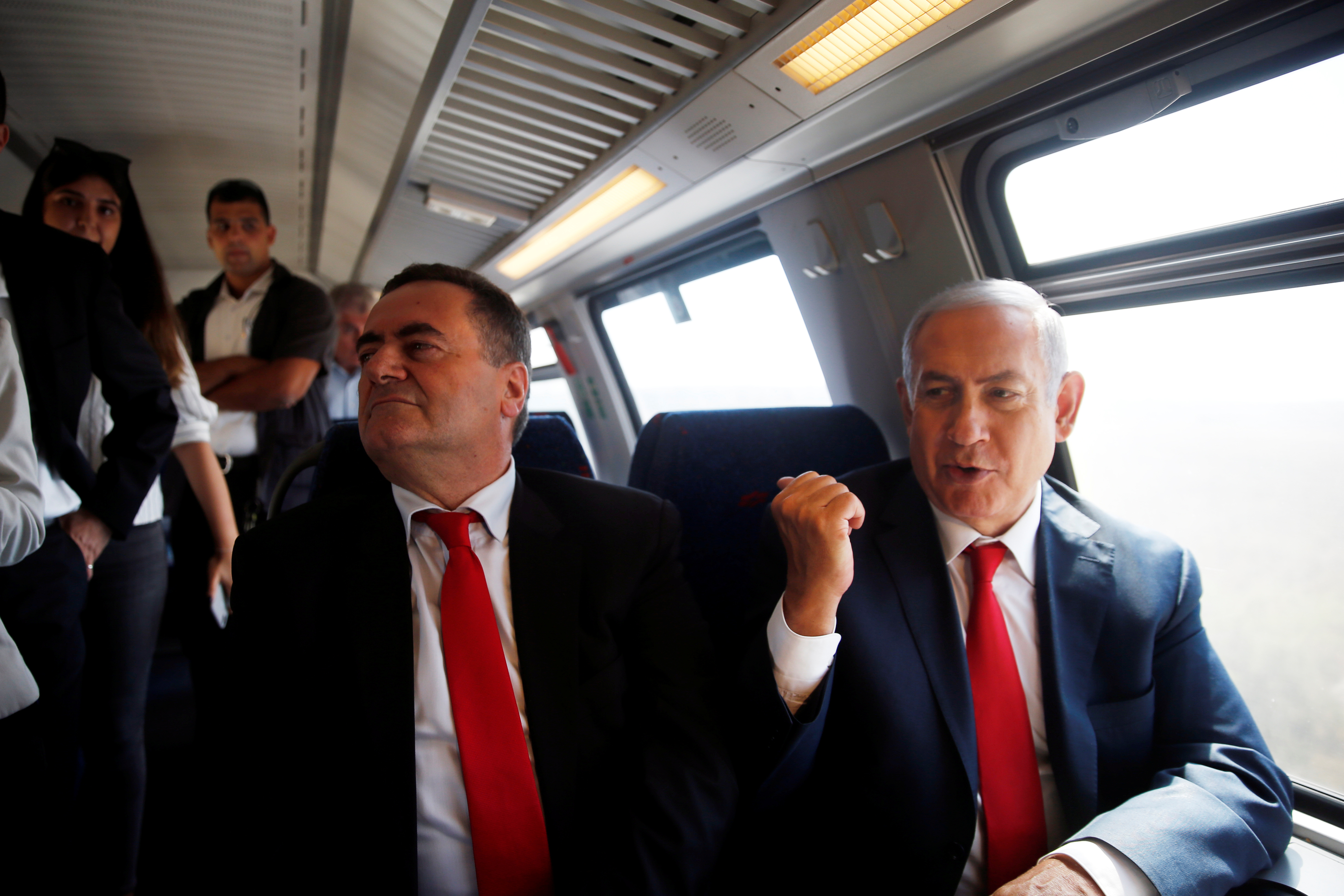 Israeli Prime Minister Benjamin Netanyahu sits next to Israel's Transportation and Intelligence Minister Katz during a test-run of the new high-speed train between Jerusalem and Tel Aviv, near Lod