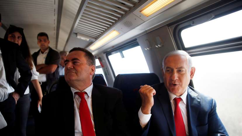 Israeli Prime Minister Benjamin Netanyahu sits next to Israel's Transportation and Intelligence Minister Katz during a test-run of the new high-speed train between Jerusalem and Tel Aviv, near Lod