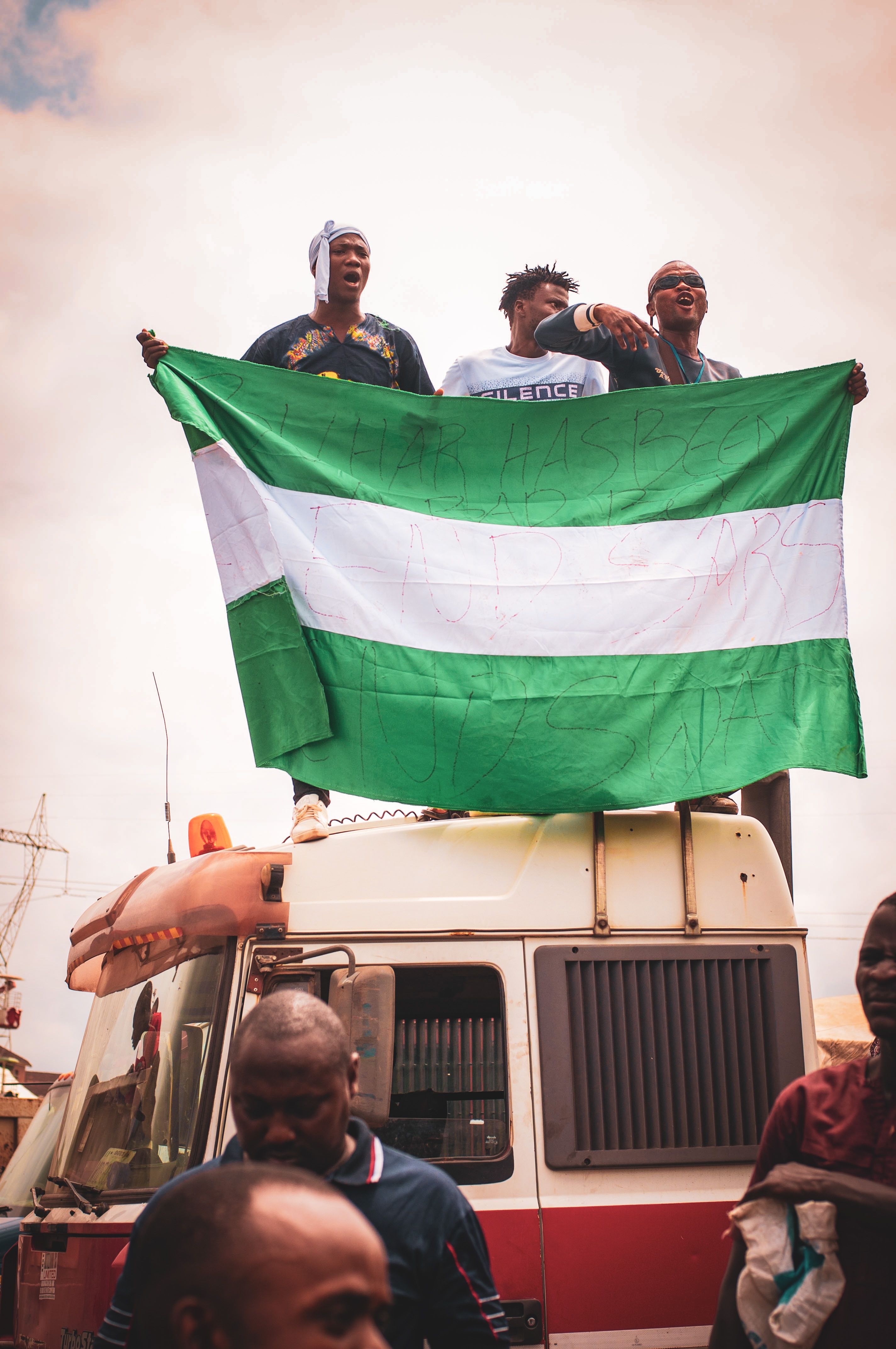 Nigerians waving the country flag on a bus