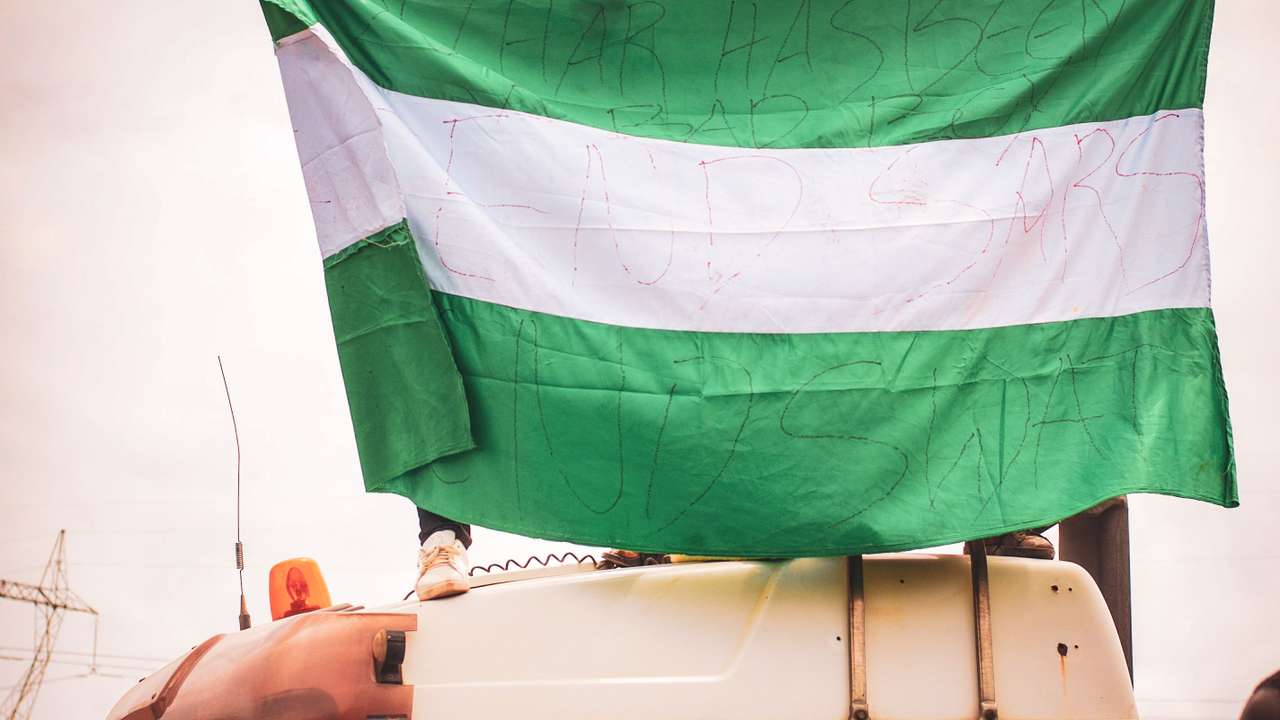 Nigerians waving the country flag on a bus