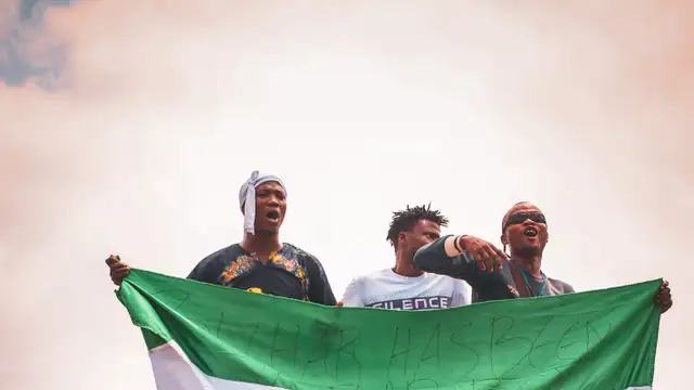 Nigerians waving the country flag on a bus