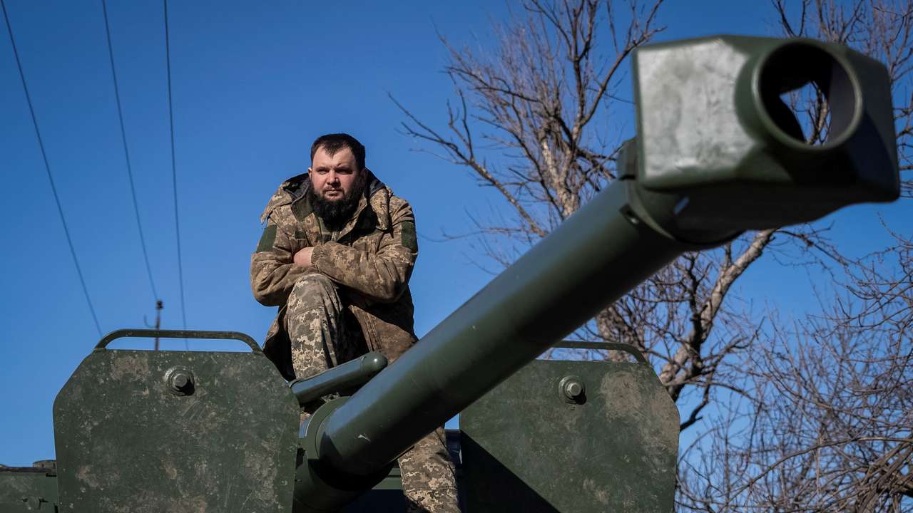A Ukrainian serviceman sits a top of a self-propelled howitzer in Bakhmut