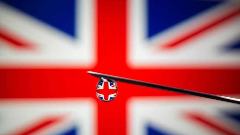 UK flag is reflected in a drop on a syringe needle in this illustration photo