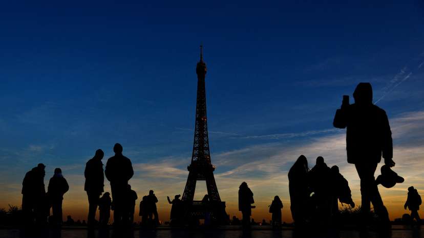 People stand at the Trocadero square near the Eiffel Tower in Paris