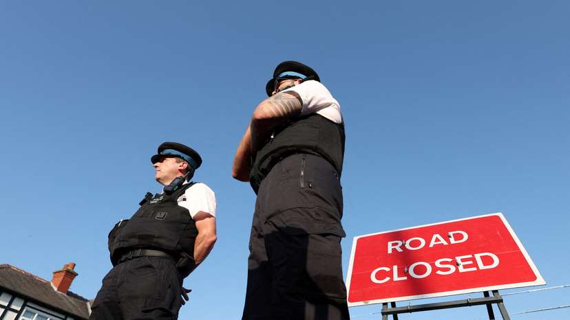 FILE PHOTO: Police officers stand near a "Road closed" sign, on the junction of Tithebarn Road and Hart Street, near the scene where a teenage suspect was arrested after people were stabbed in Southport