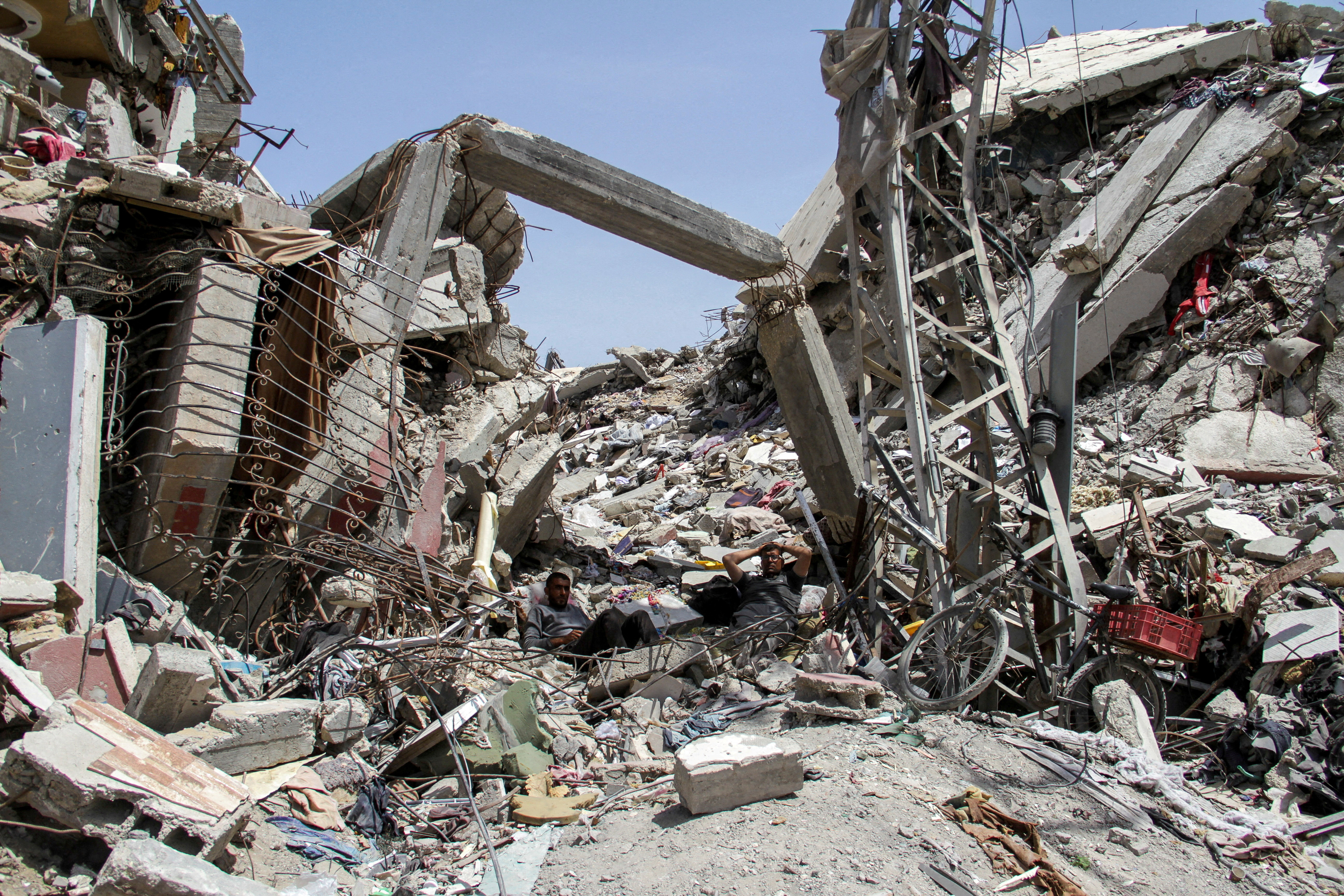 FILE PHOTO: Palestinians rest at the rubble of a residential building destroyed by Israeli strikes, amid the ongoing conflict between Israel and Hamas, in the northern Gaza Strip