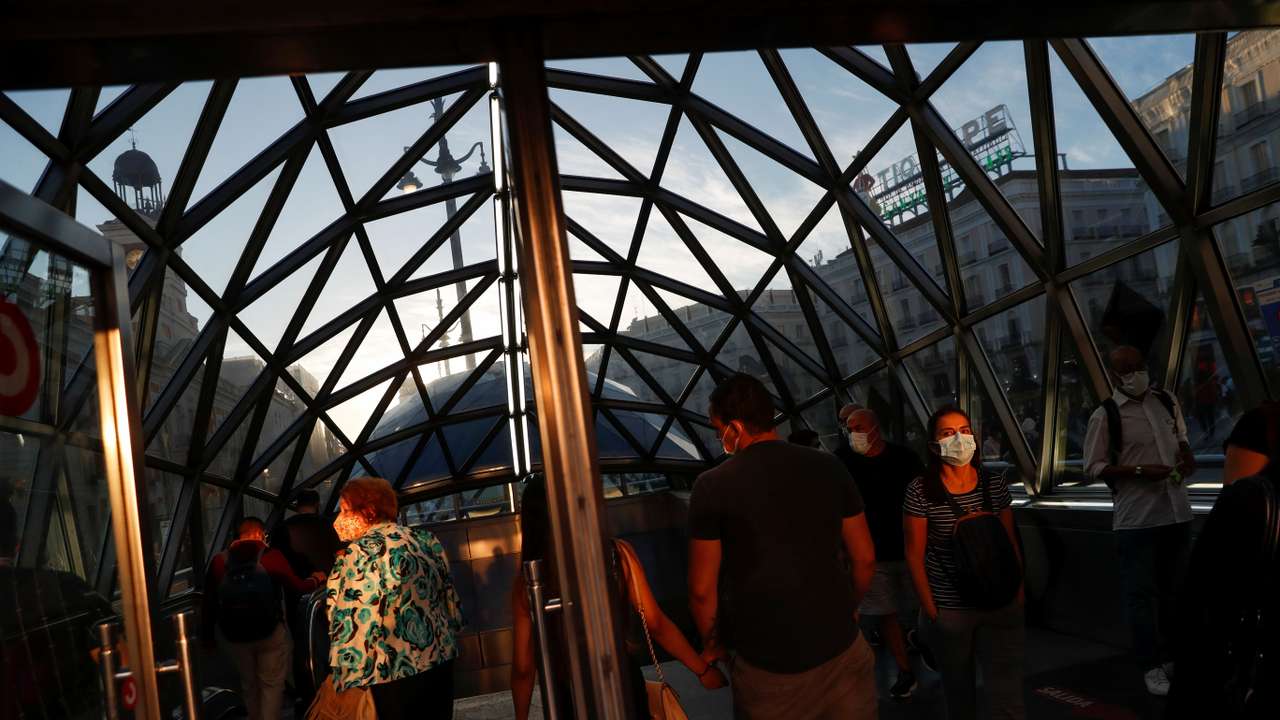 People walk in and out of a metro station at Puerta del Sol square in Madrid