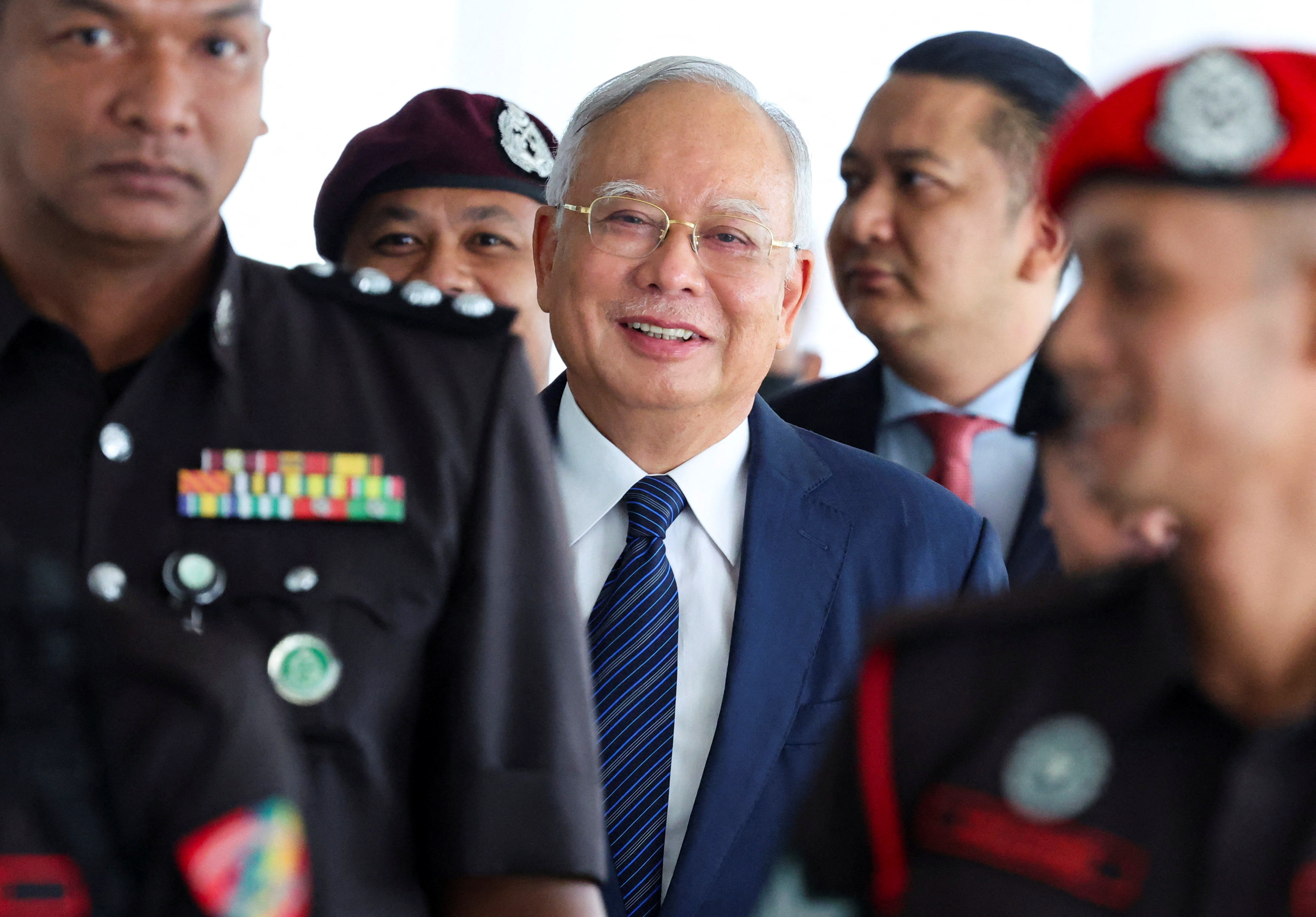 Prison officers escort former Malaysian PM Razak, in Kuala Lumpur