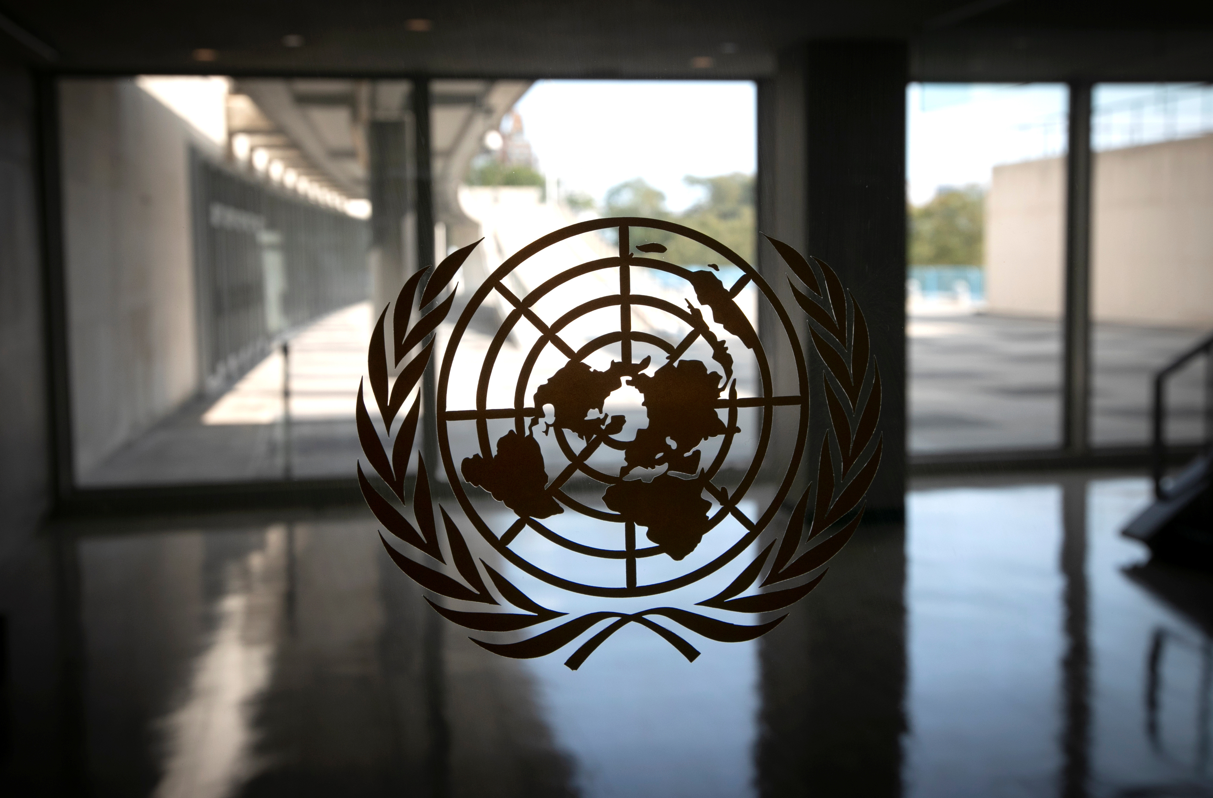 FILE PHOTO: The United Nations logo is seen on a window in an empty hallway at United Nations headquarters in New York