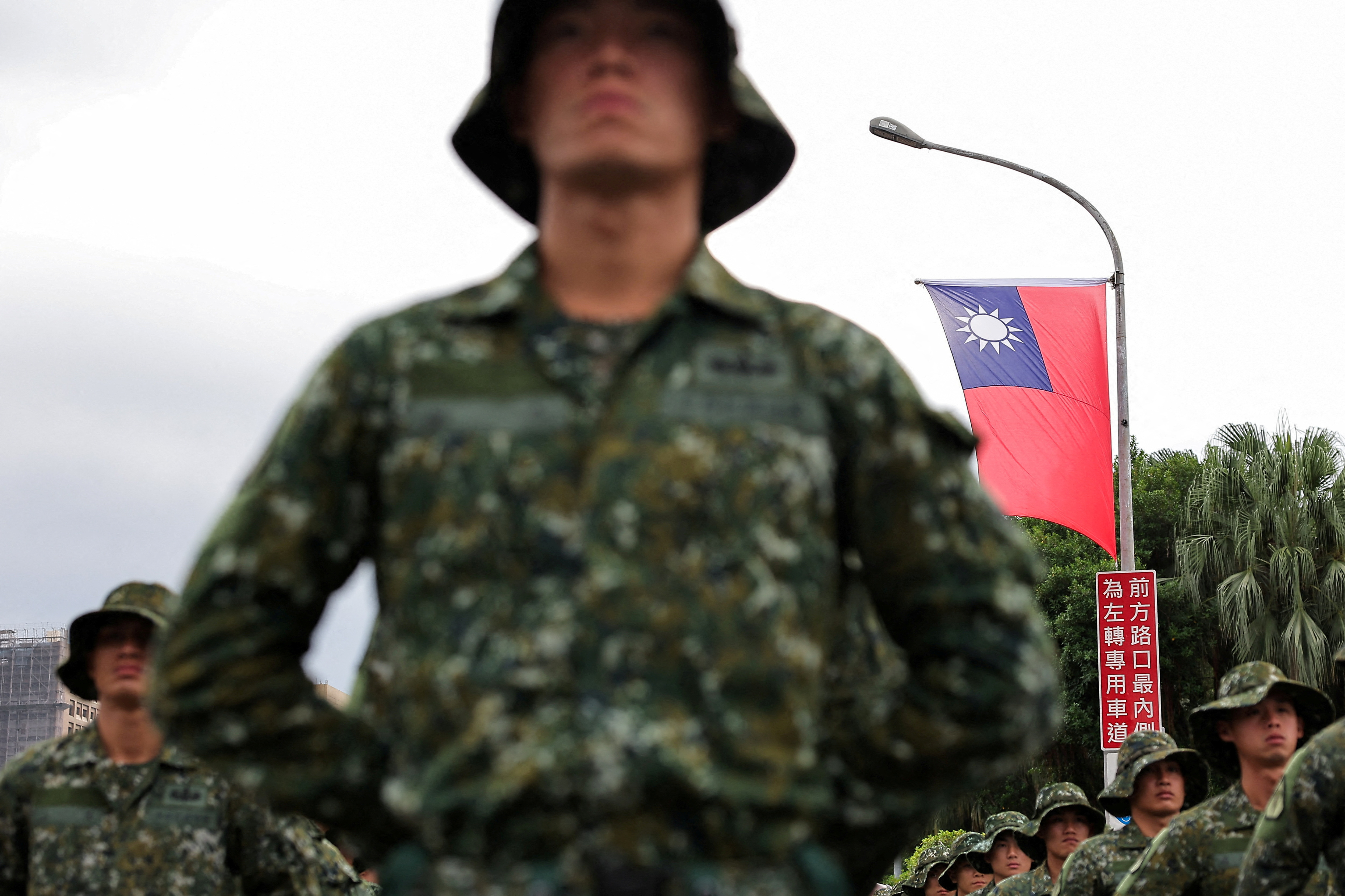 A Taiwan flag flutters in the wind as soldiers prepare to celebrate national day to mark the 113th birthday of the Republic of China