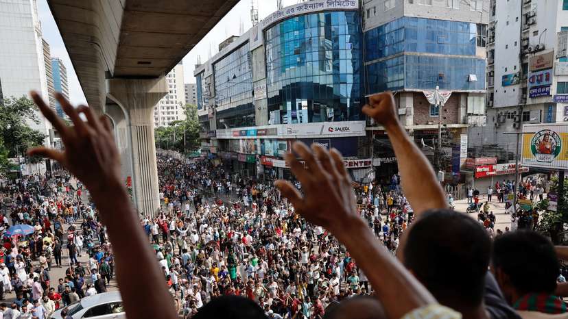 People wave hands as they celebrate the resignation of PM Sheikh Hasina in Dhaka