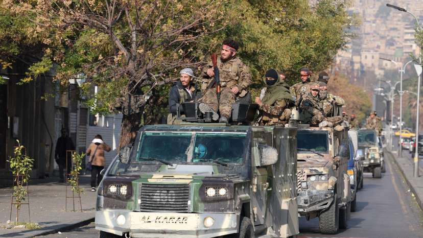 Rebel fighters ride on vehicles, in Damascus