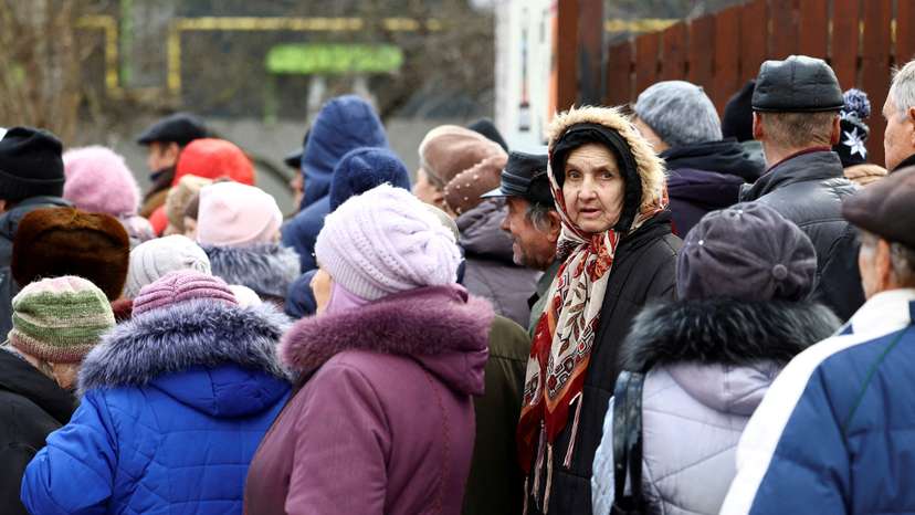 FILE PHOTO: People queue for a meal distribution in Kherson