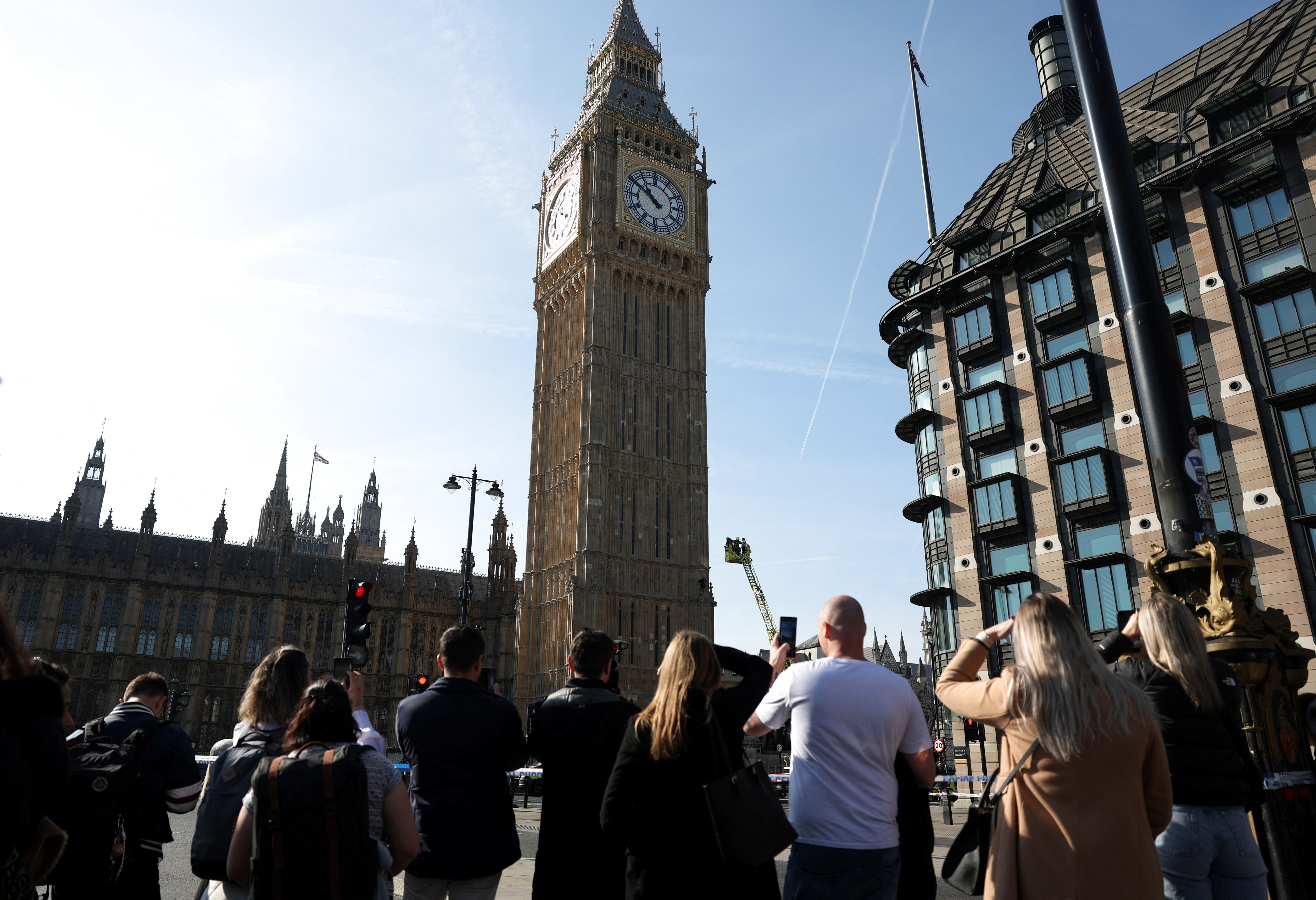 A man holding a Palestinian flag climbs Big Ben in London