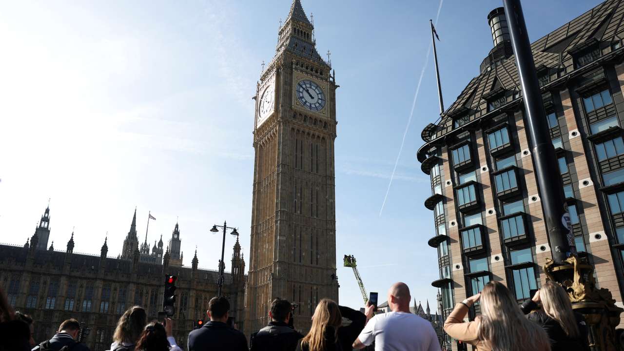 A man holding a Palestinian flag climbs Big Ben in London