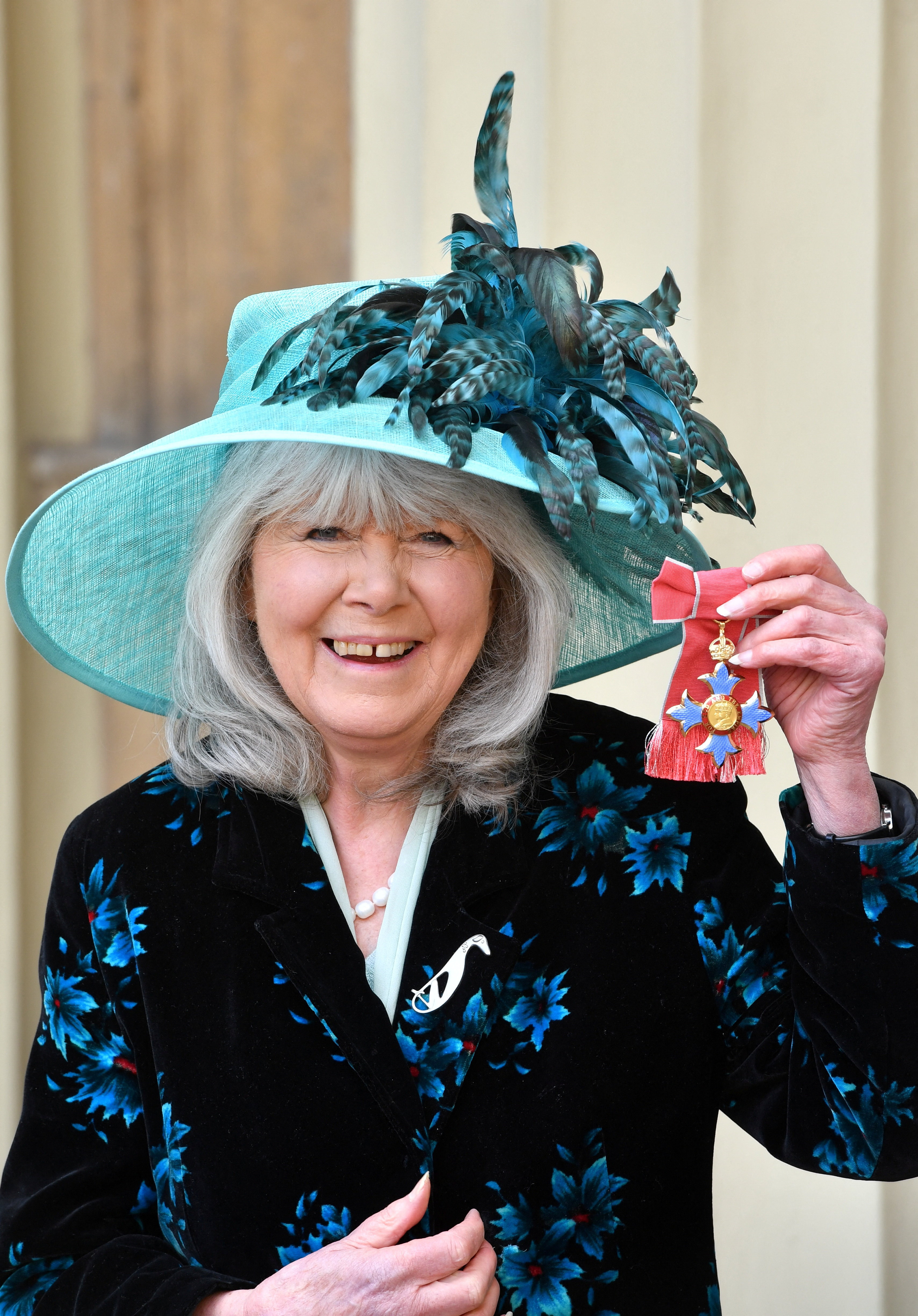 FILE PHOTO: Author Cooper poses after she was awarded her Commander of the British Empire (CBE) medal during an Investiture ceremony at Buckingham Palace, London