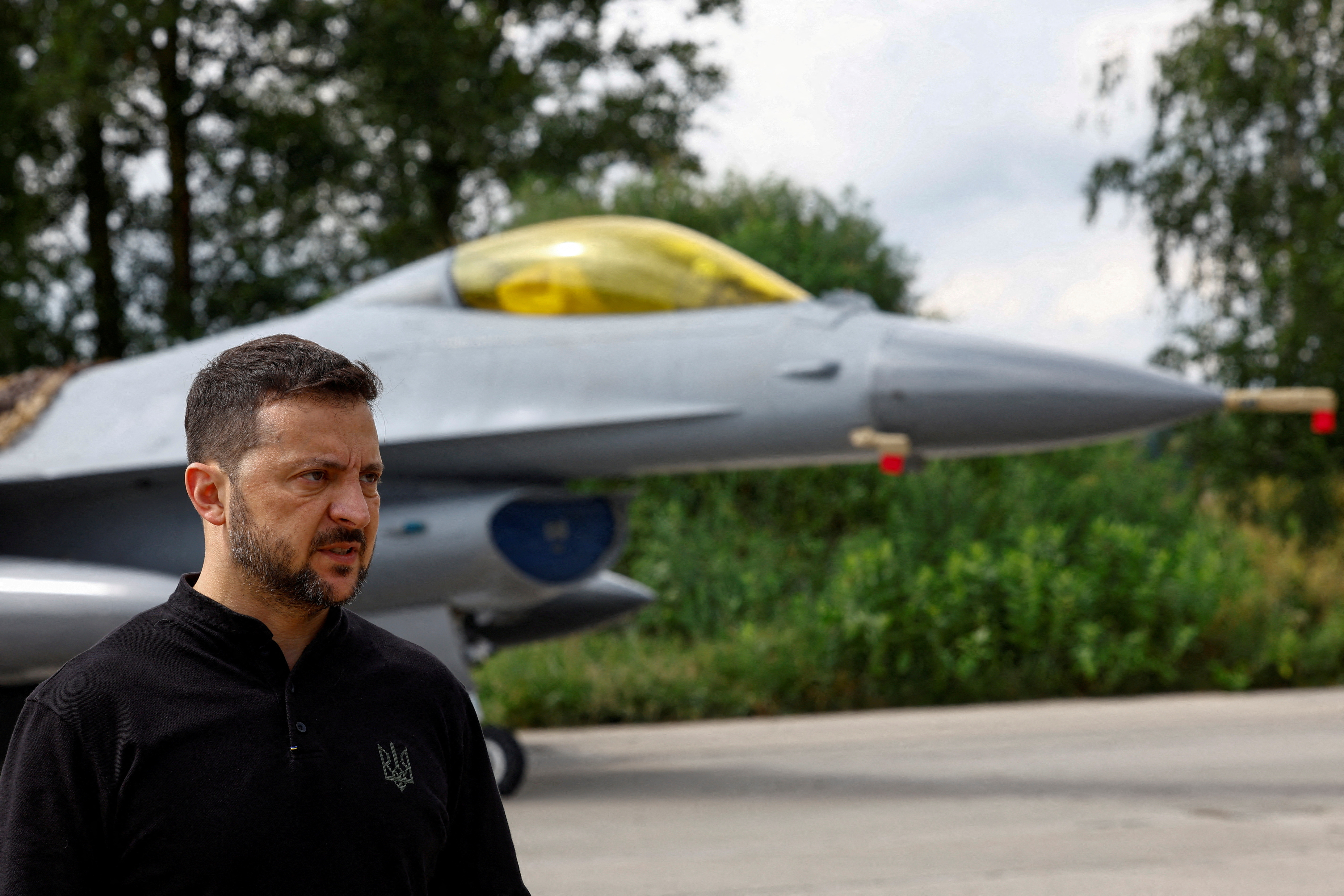 FILE PHOTO: Ukraine's President Zelenskiy speaks to the media in a front of an F-16 fighting aircraft after marking the Day of the Ukrainian Air Forces in an undisclosed location in Ukraine
