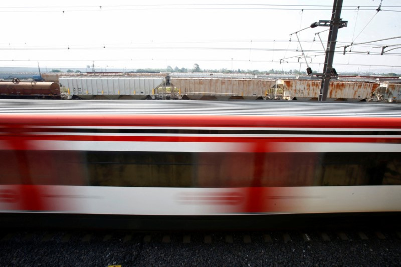 FILE PHOTO: A suburban train is passing next to a freight train in the Tlalnepantla de Baz borough of Mexico City