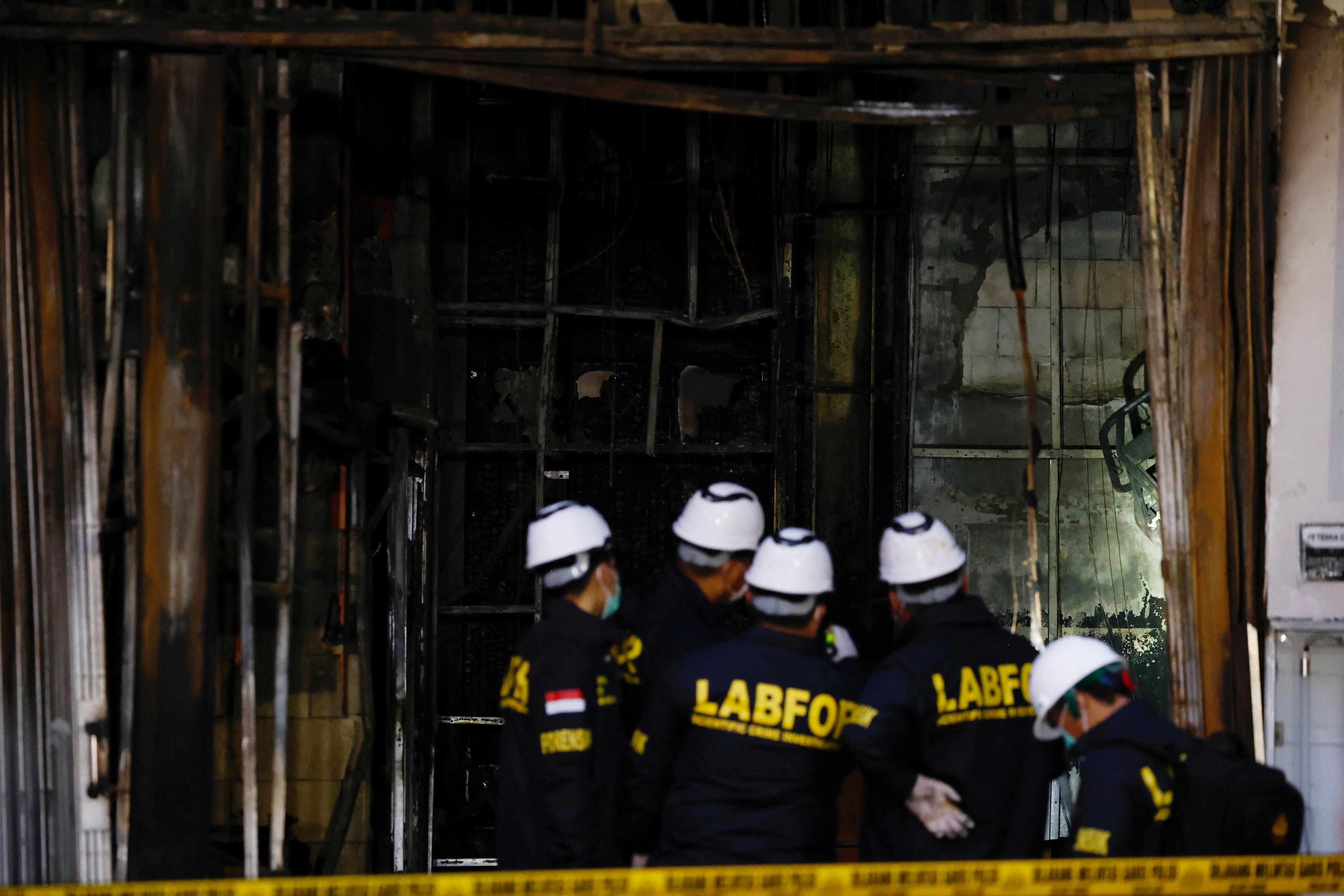 Forensic police officers inspect the Terra Drone Agri building damaged by fire, in Jakarta