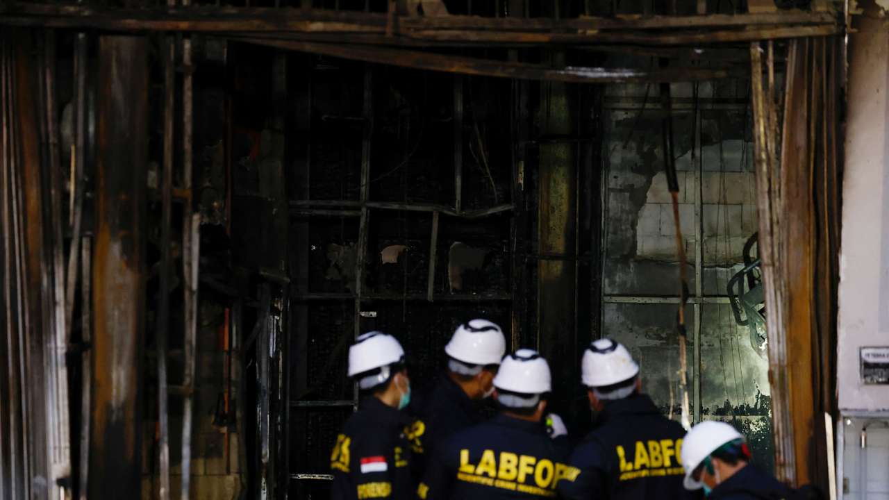 Forensic police officers inspect the Terra Drone Agri building damaged by fire, in Jakarta