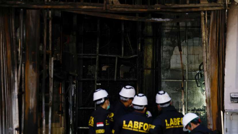 Forensic police officers inspect the Terra Drone Agri building damaged by fire, in Jakarta
