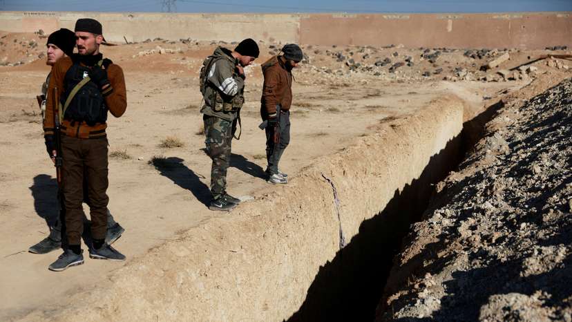 Fighters of the ruling Syrian body inspect the site of a mass grave from the rule of Syria's Bashar al-Assad, in Najha