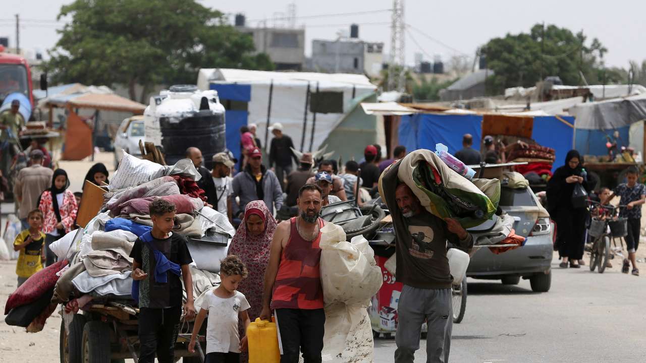 Palestinians travel on foot along with their belongings as they flee Rafah due to an Israeli military operation