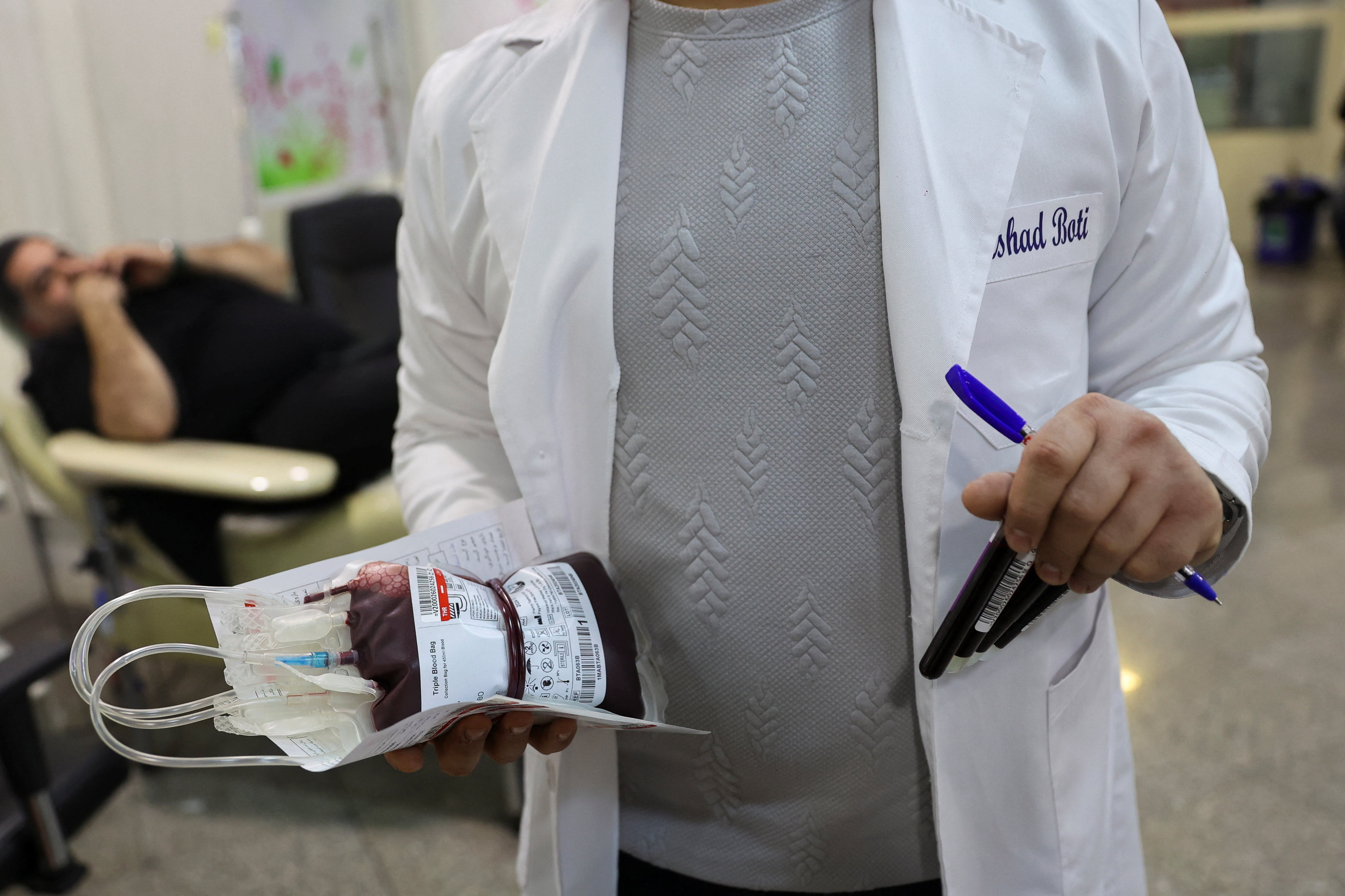 A medical worker holds a bag with donated blood, amid the U.S.-Israeli conflict with Iran, in Tehran