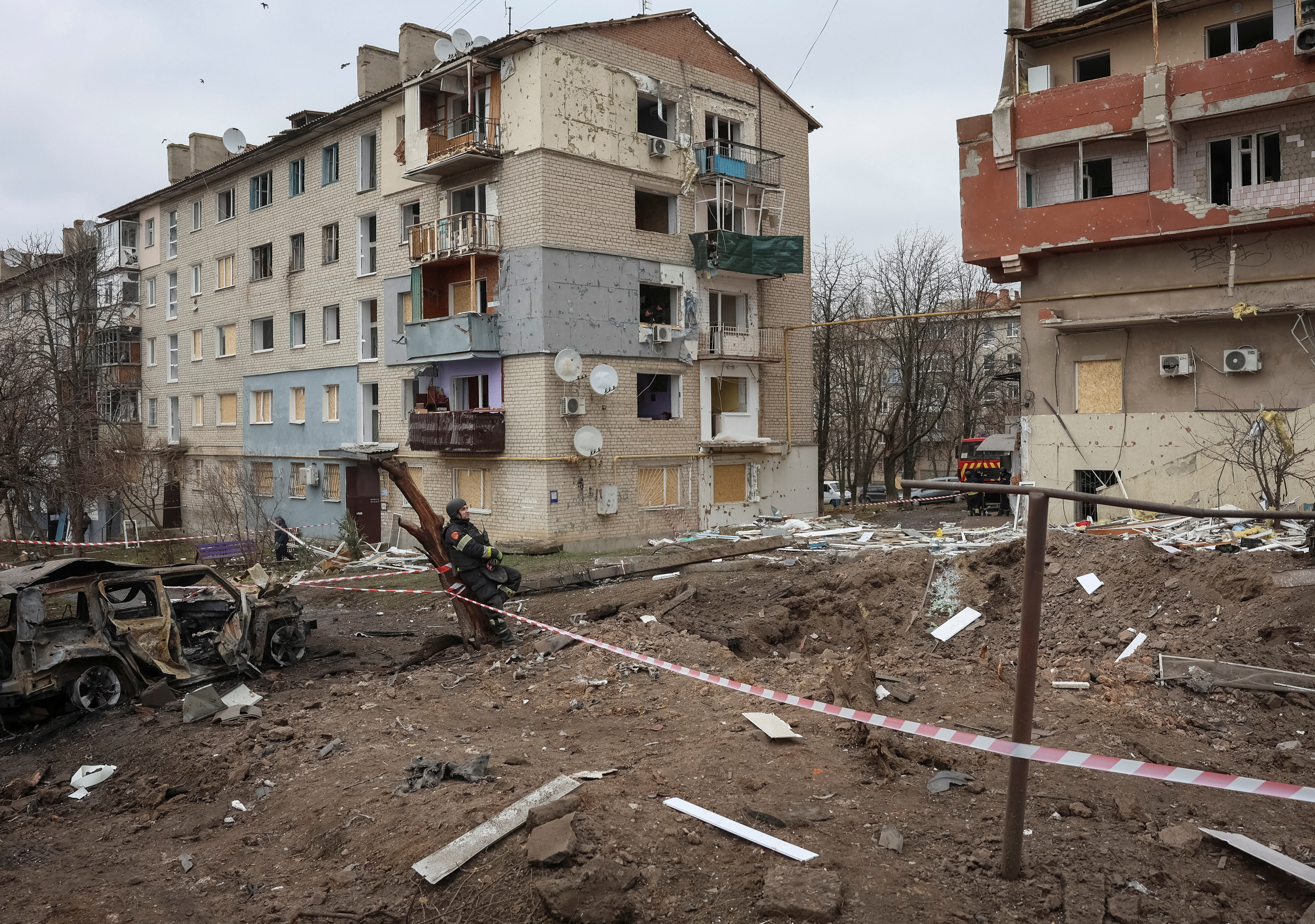 A firefighter rests at the site of apartment buildings hit by Russian missile strikes in the town of Balakliia