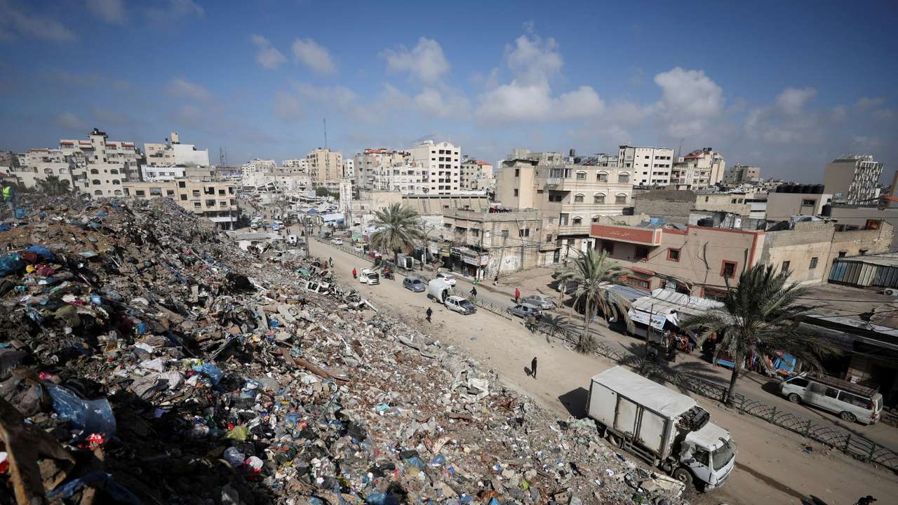 Palestinians walk near a landfill, in Gaza