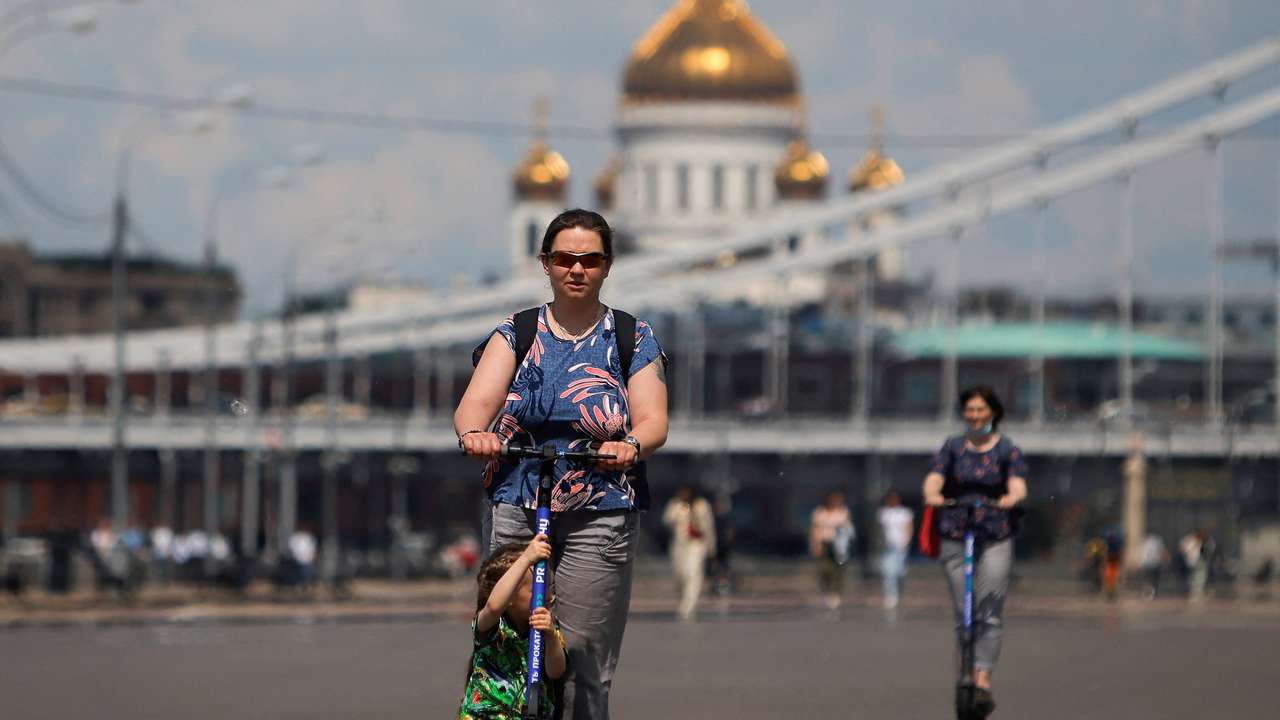 FILE PHOTO: People ride electric scooters in Moscow