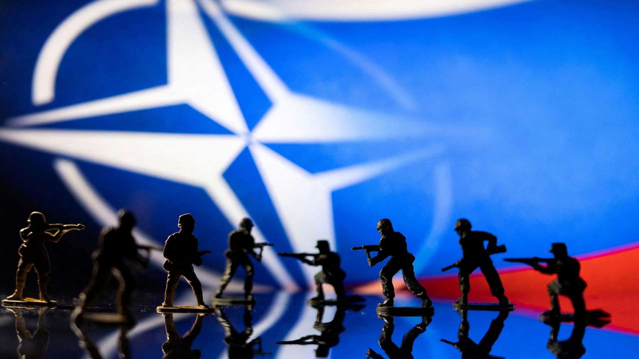 FILE PHOTO: Illustration shows army figurines on NATO logo and Russian flag colours background