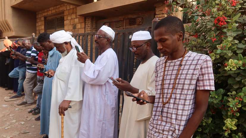Residents and displaced people try to access the internet via Starlink in the city of Omdurman