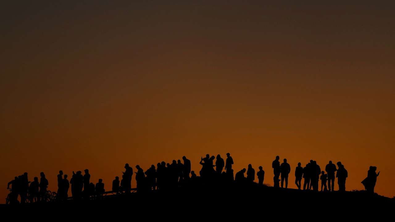 Displaced Palestinians try to get internet service on their phones through the Egyptian networks to communicate with their relatives, in Rafah
