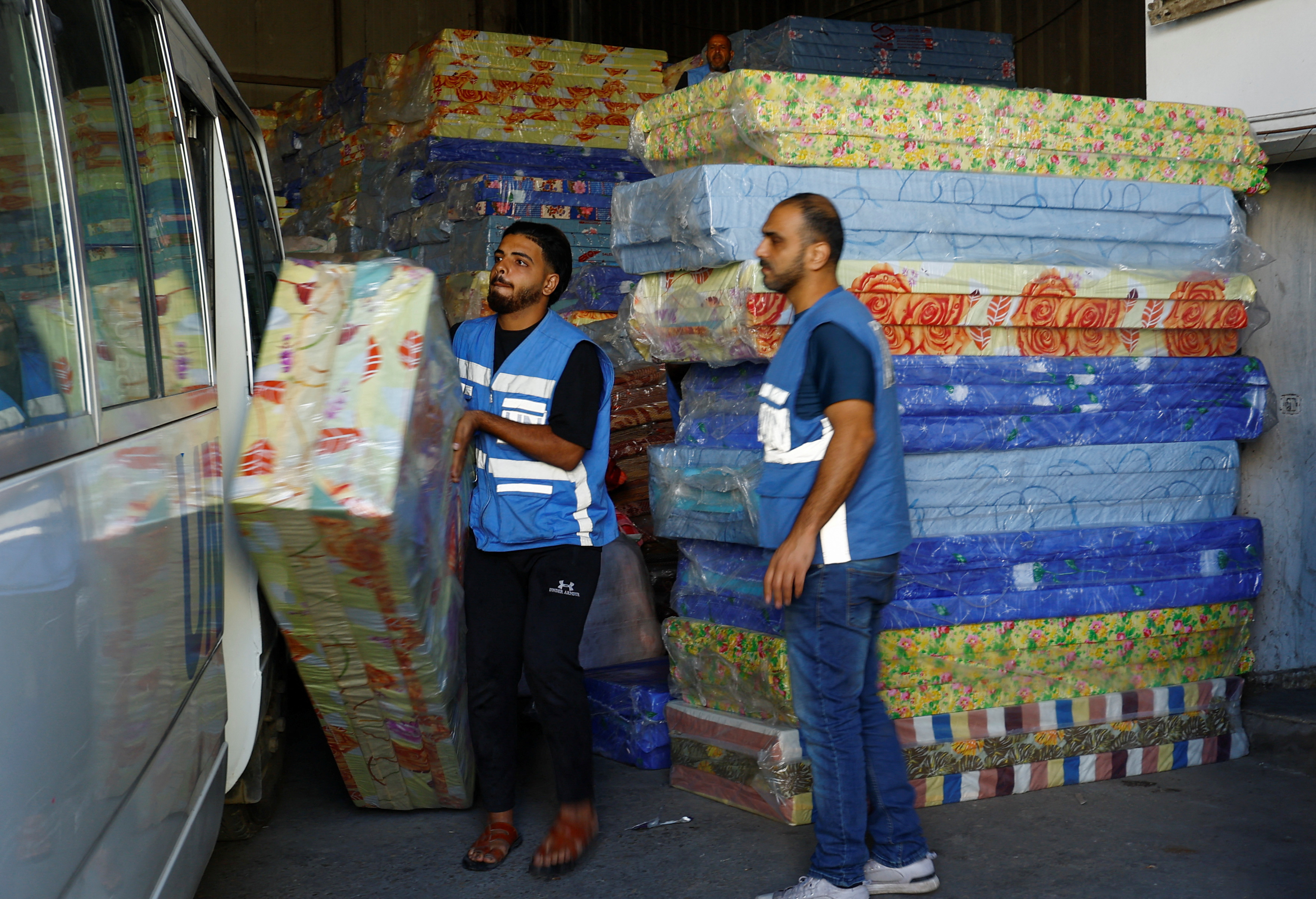 Workers sort aid to be distributed to Palestinians, at a United Nations-run facility, in Khan Younis