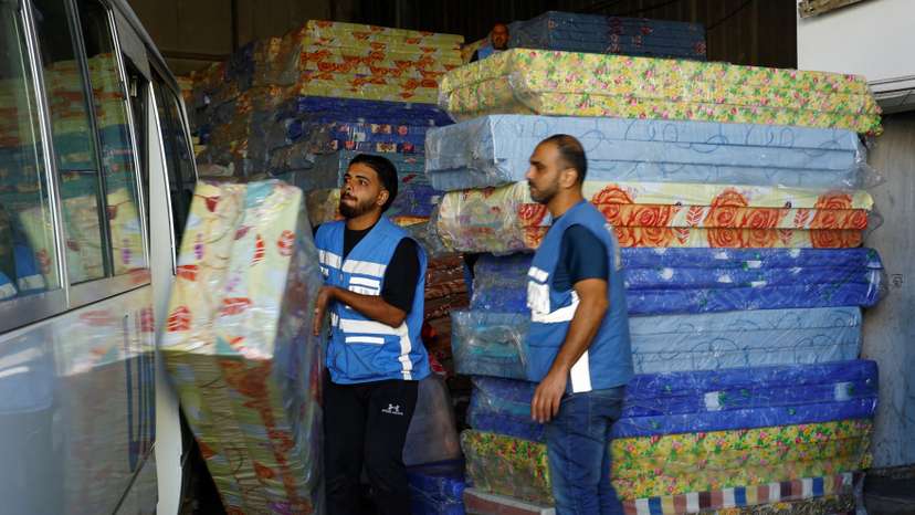 Workers sort aid to be distributed to Palestinians, at a United Nations-run facility, in Khan Younis