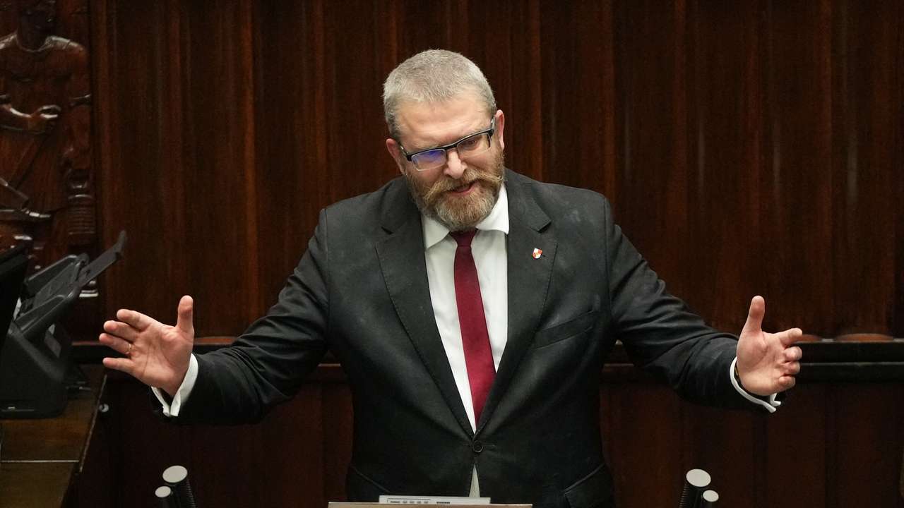 Grzegorz Braun, member of far-right political alliance Confederation, speaks after putting out Hanukkah menorah candles, at the parliament in Warsaw