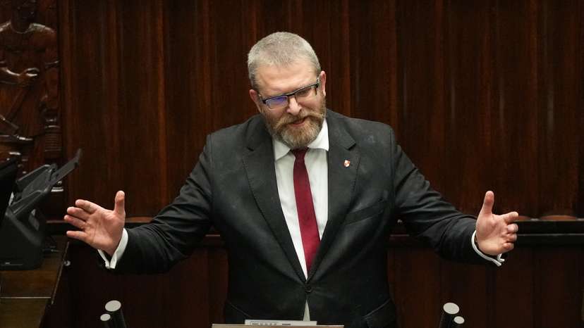 Grzegorz Braun, member of far-right political alliance Confederation, speaks after putting out Hanukkah menorah candles, at the parliament in Warsaw