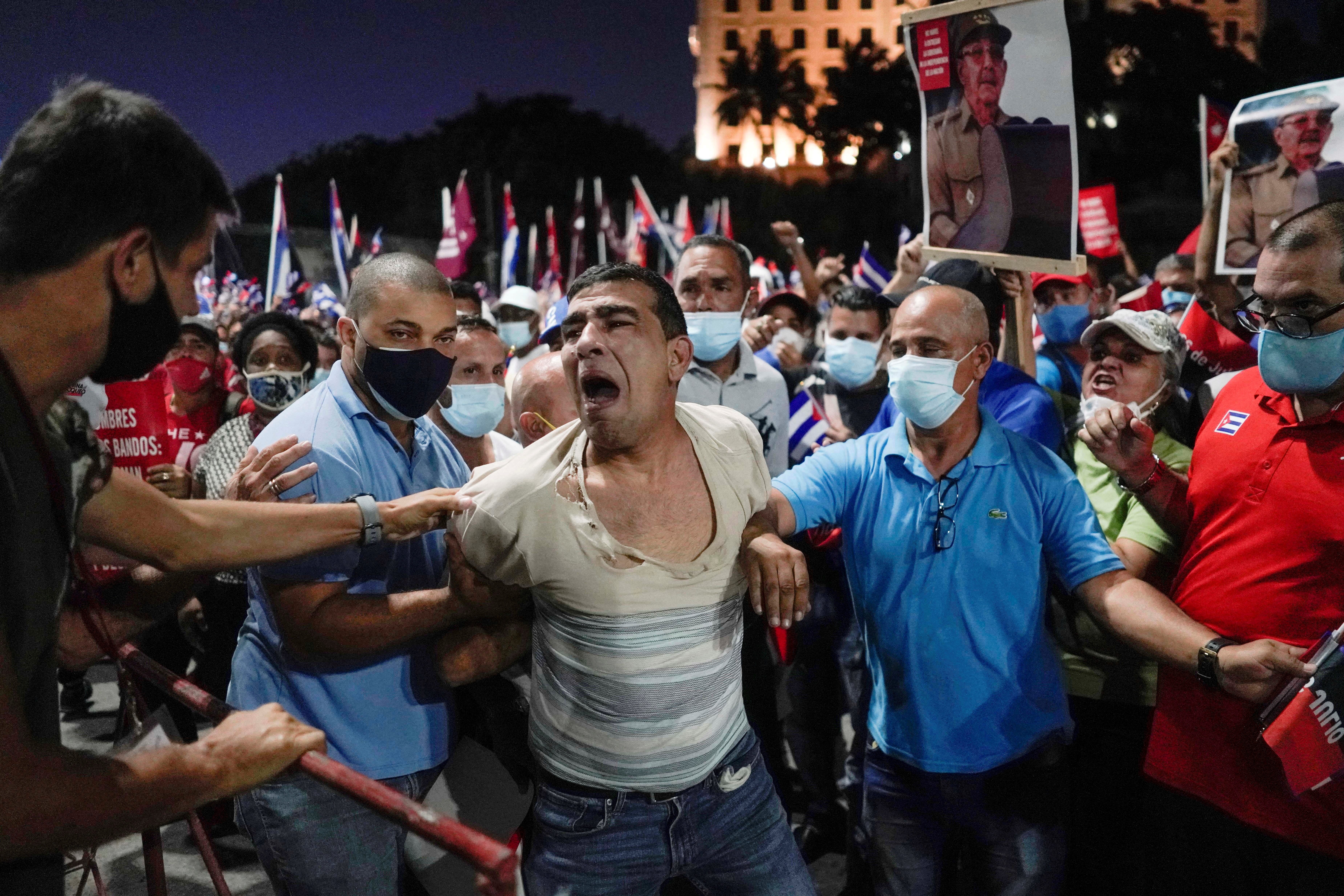 FILE PHOTO: People detain a protester during a rally in Havana