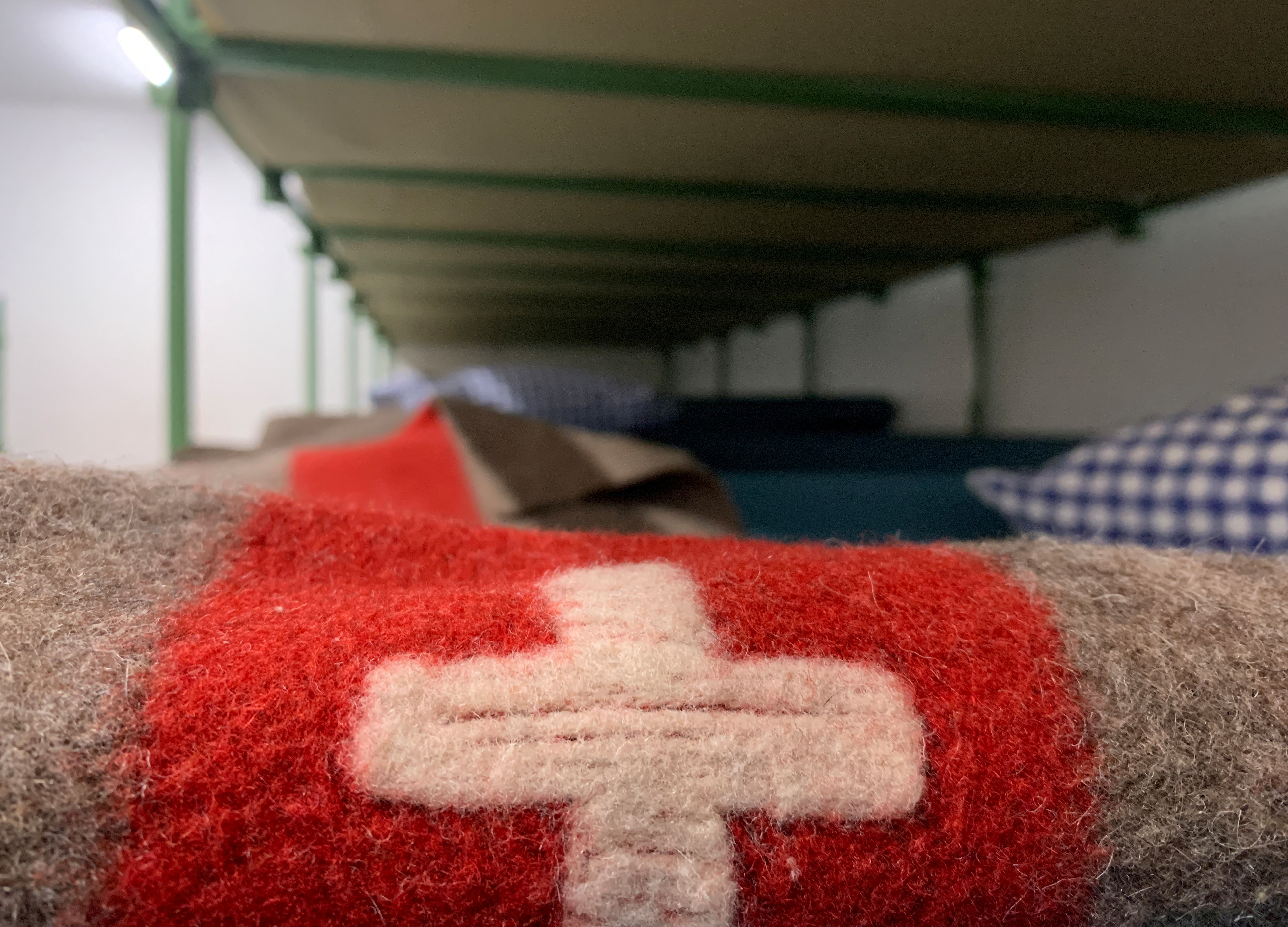 A Swiss flag is seen on a bunk bed are seen in the atomic shelter underneath the civil protection building in Gollion